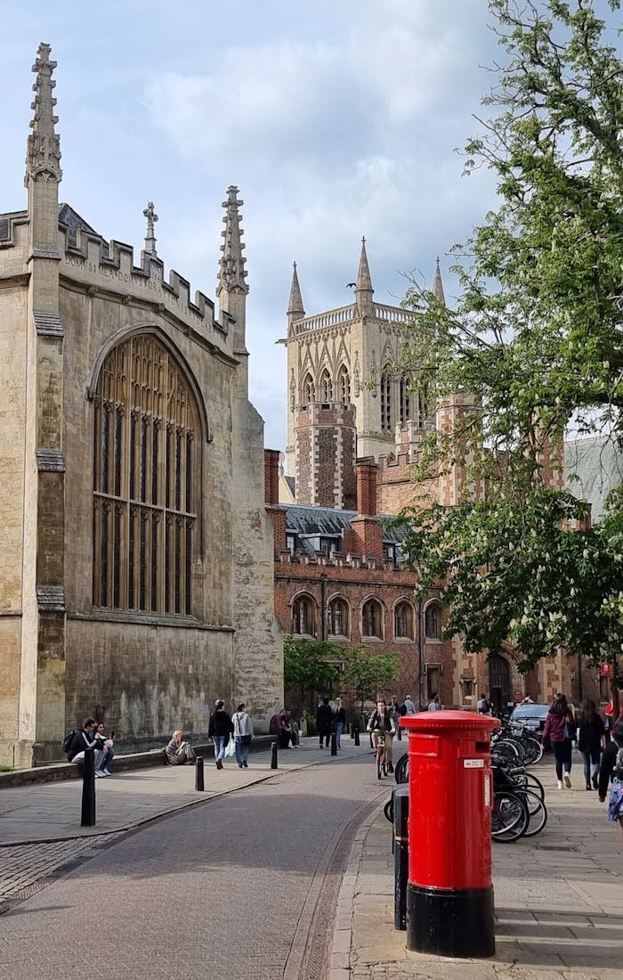 Offerings Beautiful Gothic buildings line a bustling street in Cambridge, UK.