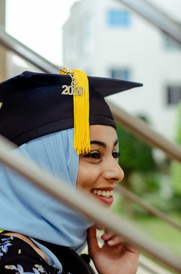 Smiling young woman in a graduation cap, celebrating academic achievement.