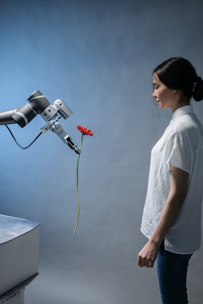 Mastering the First Impression: Your intriguing post title goes here A woman observes a robot holding a red flower, symbolizing technology and nature integration.